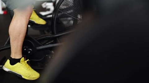 Side view close-up part of young man in sports shoes cycling at gym. slider shot Stock Footage 62446750
