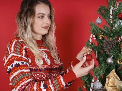 Side view close up portrait of young caucasian woman decorating a Christmas tree Stock Photos