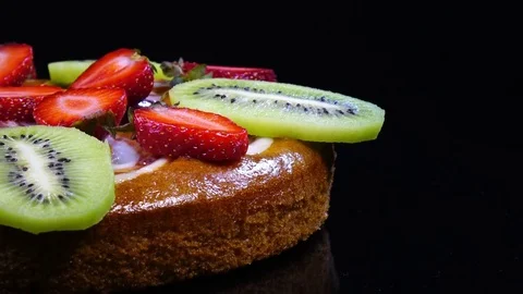 Side-view close up of round pie with sliced fresh strawberries and kiwi-fruit Stock Footage 78355425