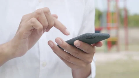 Side view. Close up shot Hand of women using smartphone in the park Stock Footage 131581873