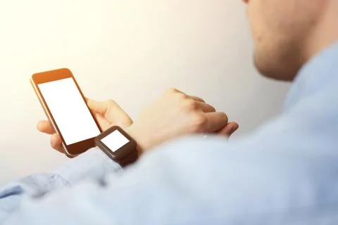 Side view, close-up of a smartphone with a blank screen and a smart watch on  Stock Photos