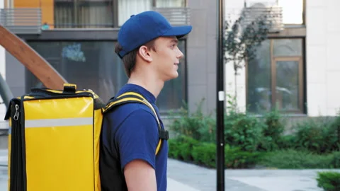 Side view close up smiling food delivery man courier with thermal backpack Stock Footage 156485881