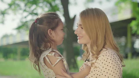 Side view close-up of smiling young blond mother and brunette little daughter Stock Footage 135308356