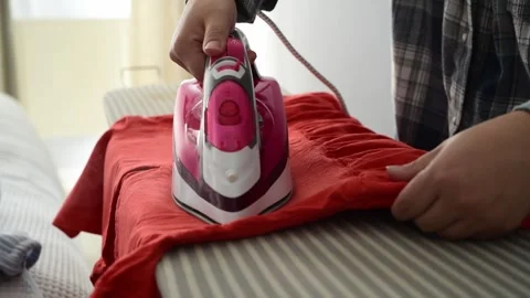 Side view close up of woman hands steaming clothes with an iron 库存影片 328318970