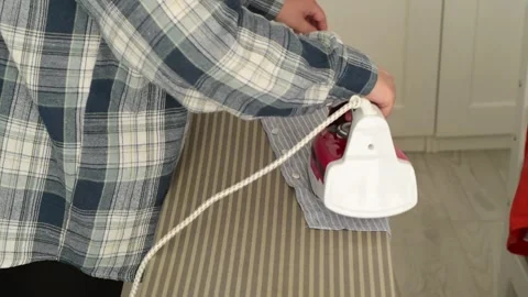 Side view close up of woman hands ironing clothes on an ironing board. Vídeo Stock 328318989