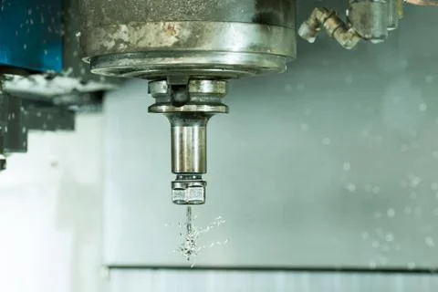 Side view on CNC milling machine drill with metal shaving scrap on it Stock Photos