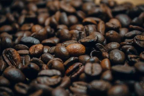 Side view. Coffee beans lie on the table in a large pile. Roasted coffee beans Stock Photos
