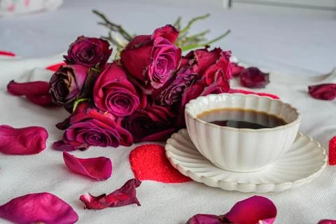 Side View Coffee Cup with Red Roses and Petals Foto stock