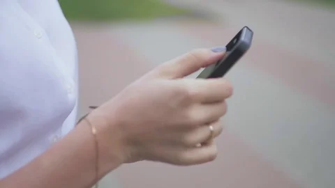 Side view of a college girl text messaging mobile phone in the park. closeup Stock Footage 81220927