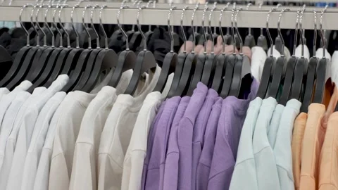 Side view of colorful cotton t-shirts hanging on hanger in a store. Stock Footage 272554902