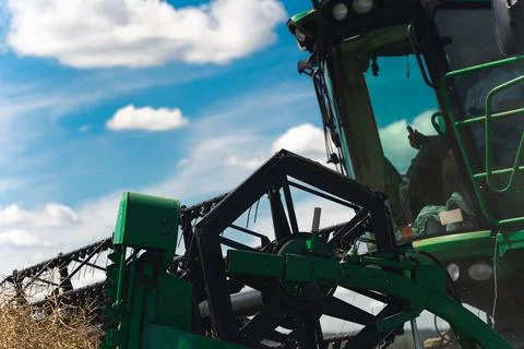 A side view of a combine drivers cabin and a revolving reel - a male farmer Stock Photos