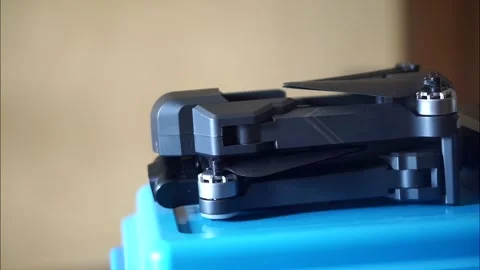 Side view of a compact folding drone and battery module prepared Stock Footage 323304585