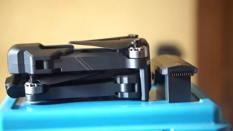 Side view of a compact folding drone and battery module prepared Stock Footage 323304620