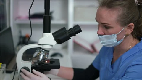 Side view concentrated Caucasian laborant analyzing blood sample with microscope Stock Footage 200859691