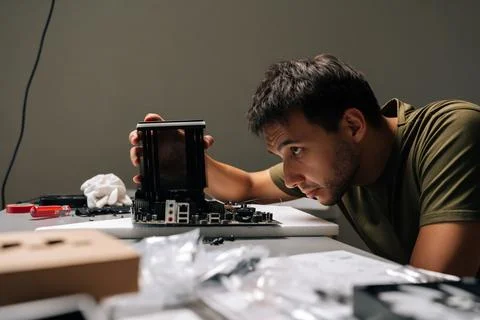 Side view of concentrated computer technician male carefully installing CPU Stock Photos