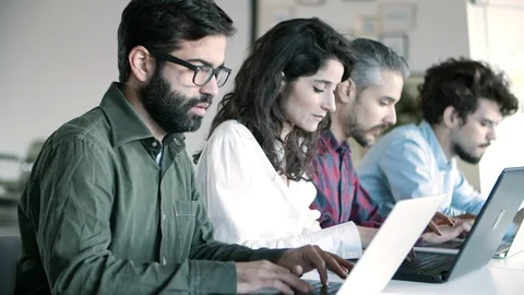 Side view of concentrated programmers working with laptops Stock Footage 121401902