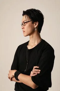 Side view of confident young asian man wearing glasses and posing indoor. Stockfoto's