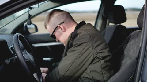 Side view of confident young stylish man in sunglasses in his car Stock Photos