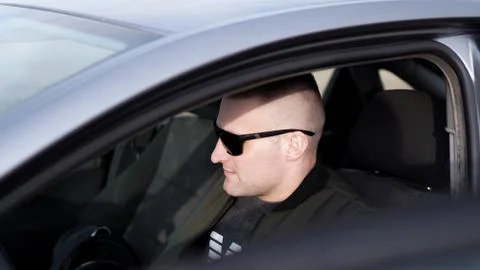 Side view of confident young stylish man in sunglasses in his car Stock Photos