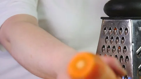 Side view cook grates carrots on a grater Stock Footage 76086469