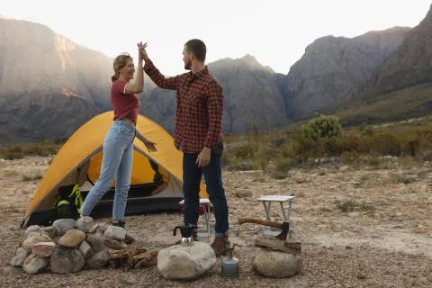 Side view of couple doing a high five outside Stock Photos