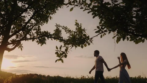 Side view of a couple holding hands taking a walk together in the country side Stock Footage 247950009