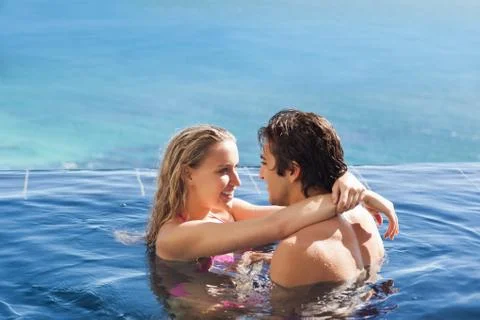 Side view of couple hugging in the pool 스톡 사진