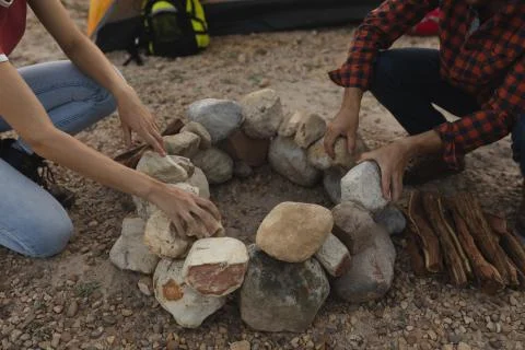 Side view of couple installing rocks for a campfire Photos