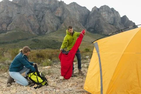 Side view of couple installing the tent together Fotos Stock