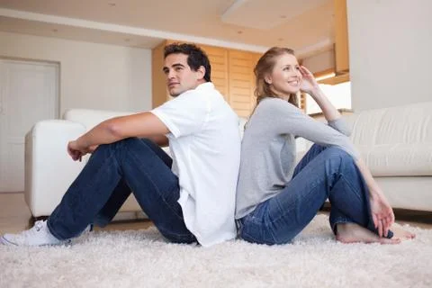 Side view of couple sitting back-to-back Stock Photos