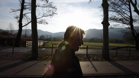 Side view of couple walking at sunset Stock Footage 101934932