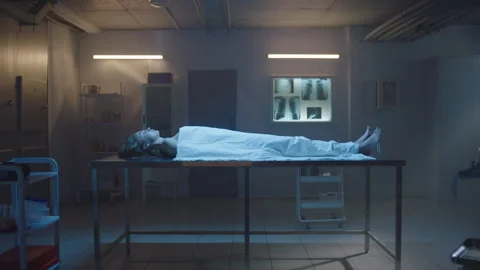 Side view of Covered body of a deceased woman on the table at the morgue Stock Footage 283143683