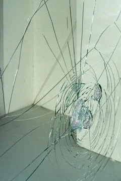 Side view of cracked storefront glass with broken impact pattern and urban .. Фото