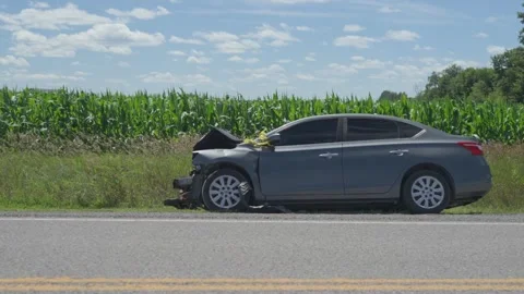 Side View of Crashed Sedan on Asphalt Highway Shoulder near Cornfield Stock Footage 340542773