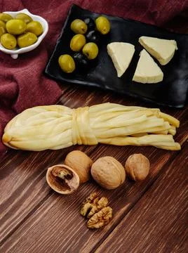 Side view of cream cheese in triangle shape with pickled olives on a black .. Stock Photos