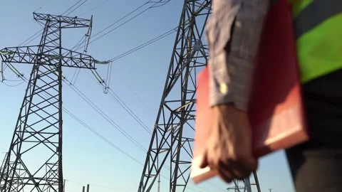 Side view of crop Inspector with folder checking high voltage power line Stock Footage 143673232