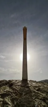 Side view of a cross on the side of a mountain with the sun illuminating it Stock Photos