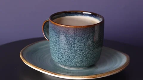 Side view on a cup and blue and brown plate moving on turn table. Stock Footage 242716913