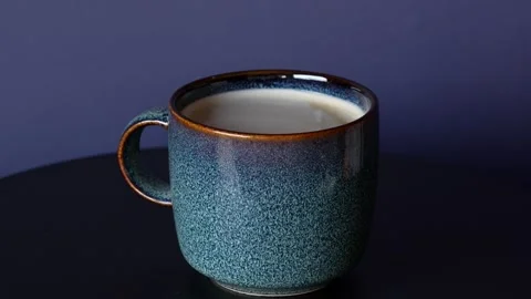 Side view on a cup and blue and brown plate moving on turn table. Stock Footage 242717032