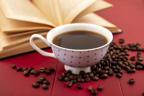 Side view of a cup of coffee with coffee beans isolated on a red background Stock Photos