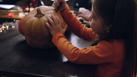 Side view of cute child in witch costume painting Stock Footage 253186956