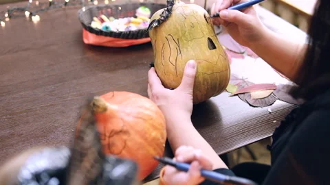 Side view of cute child in witch costume painting Stock Footage 253186984