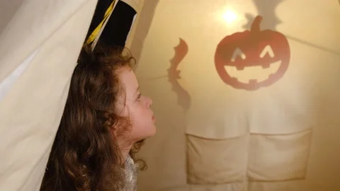 Side view of cute daughter watching mother puppet show for Halloween Stock Footage 140670299
