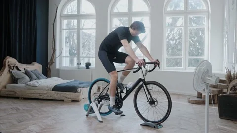 Side view of a cyclist training on an exercise bike staying at home Stock Footage 171117802