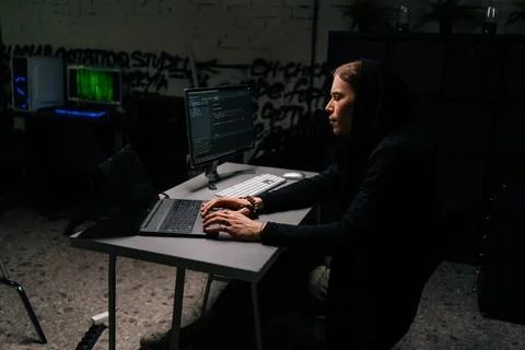 Side view of dangerous hacker man in sweatshirt hacking online web site Stockfoto's