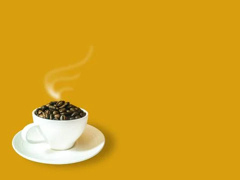 Side view. Dark brown coffee beans in white coffee cup and saucer Stock Photos