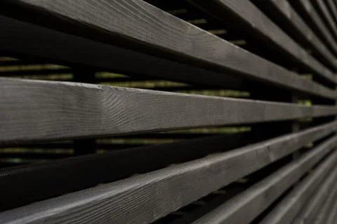 Side view of a decorative wall of black horizontal wooden bars Stock Photos