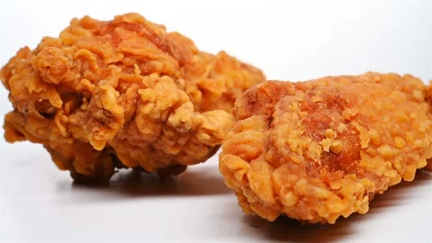 Side view deep fried chicken drumstick and wing rotating and pause Stock Footage 111507114