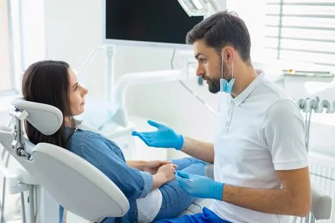 Side view of dentist talking with client in hopital Stock Photos