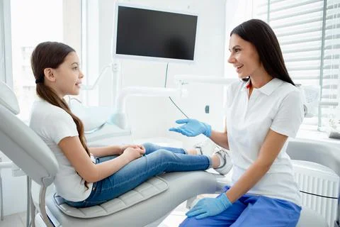 Side view of dentist talking with small girl in hopital Stock Photos